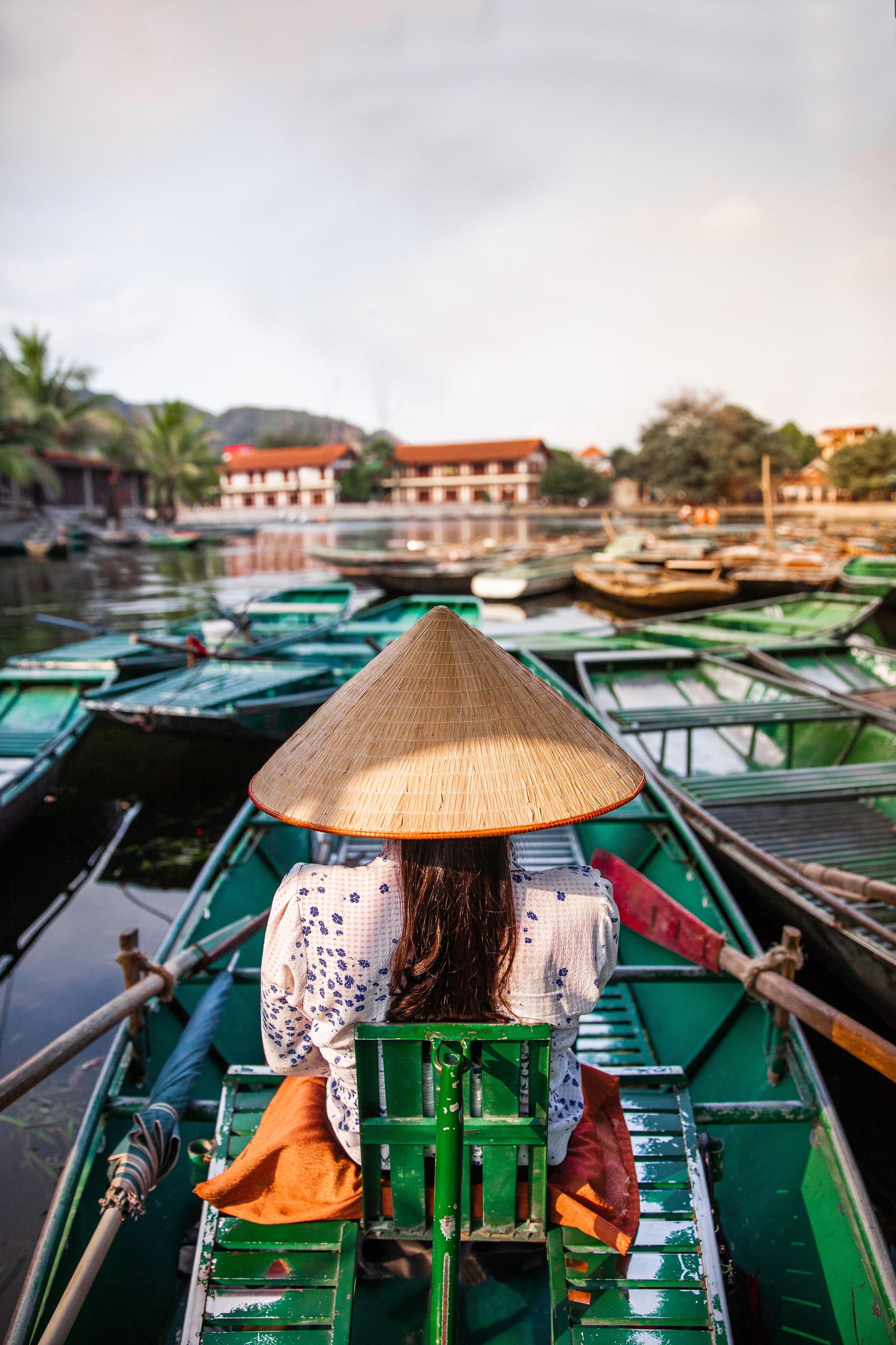 Vietnamese woman rowing a boat in river